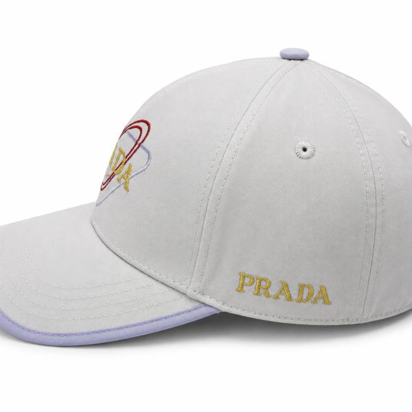 Light gray Prada baseball cap with a lavender brim and gold 'PRADA' embroidery on the front.