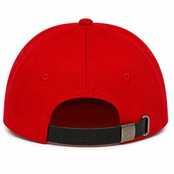 Back view of a red baseball cap with an adjustable black strap and metal buckle (MONASTERY branding).
