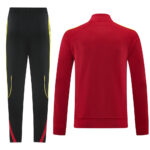 Red athletic track jacket and black training pants with yellow piping, part of a sports tracksuit set.