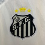 Embroidered sports crest with a yellow crown and star accents above a shield on a striped white fabric background