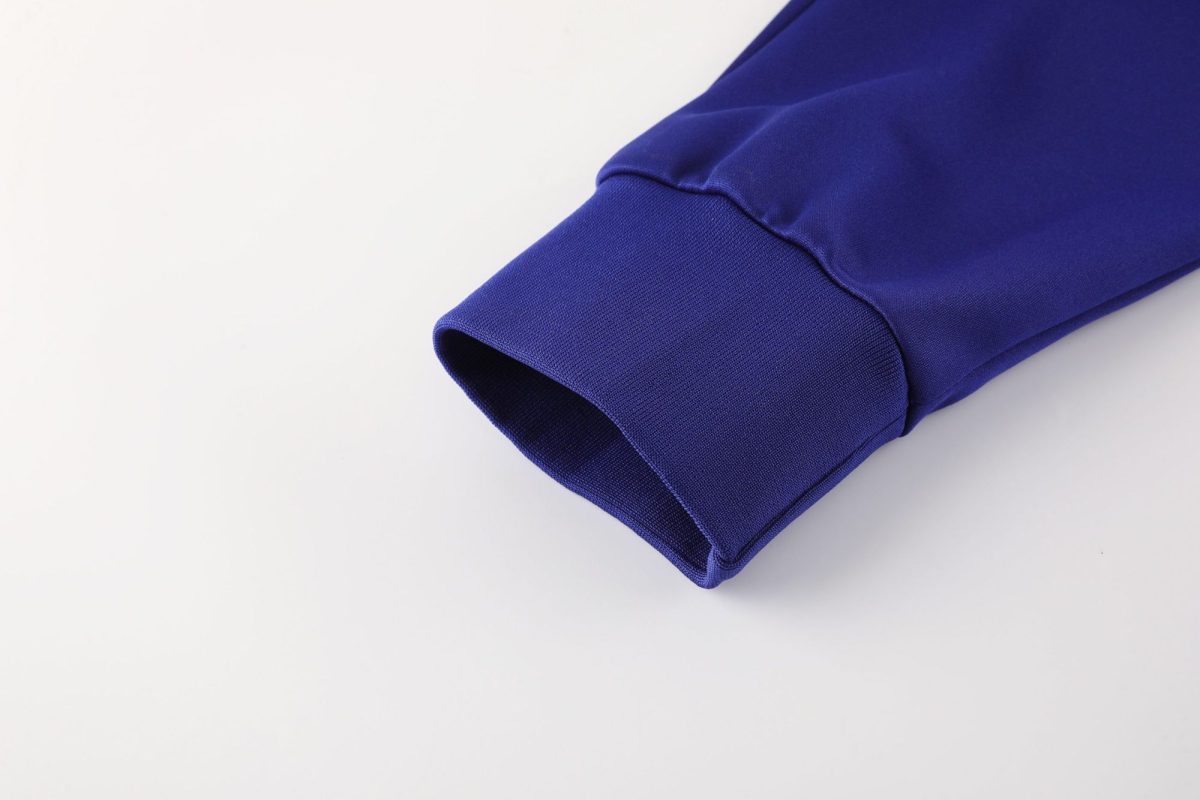 Close-up of a cobalt purple sleeve cuff folded on a white surface.