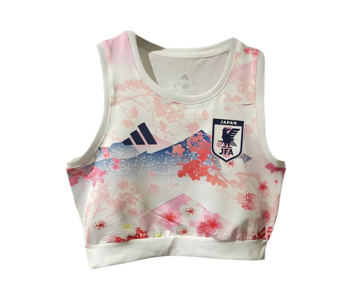 White sleeveless athletic top with pink floral pattern and a Japan Football Association badge on the chest, Adidas logo nearby.