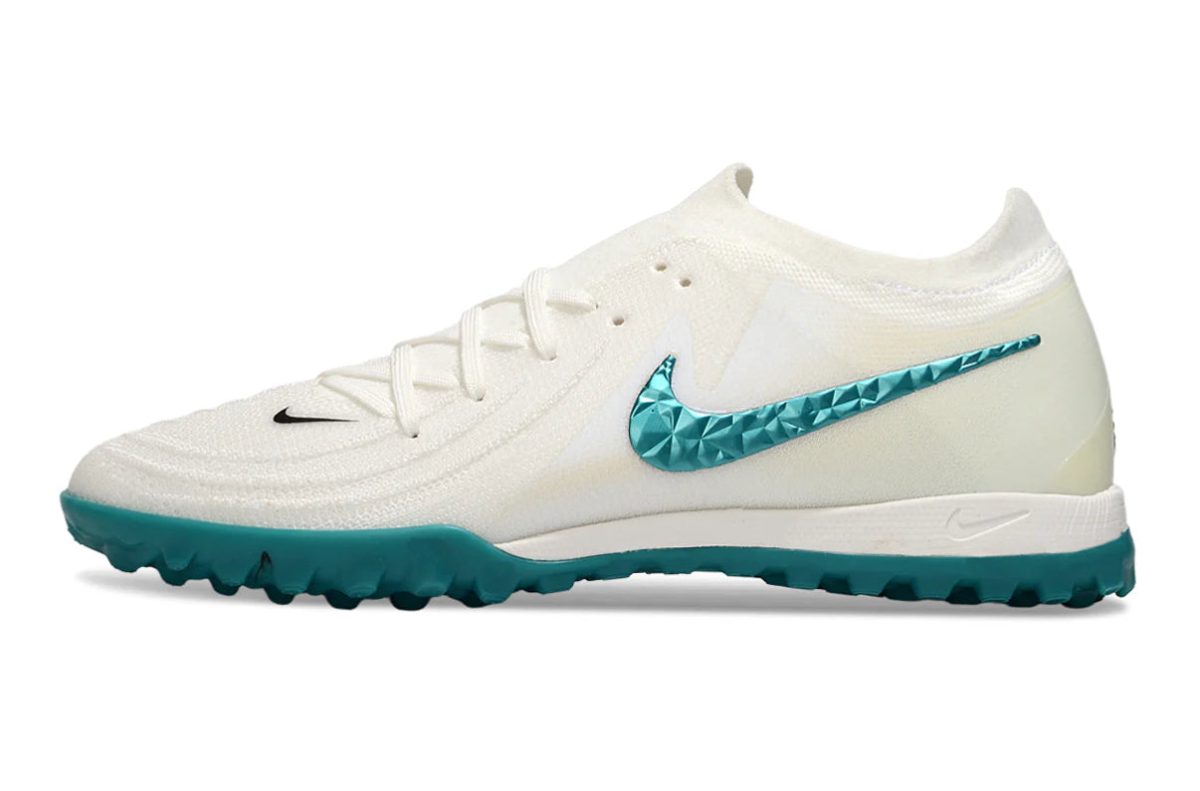 White Nike running shoe with teal studded Swoosh logo and teal outsole on a white background.