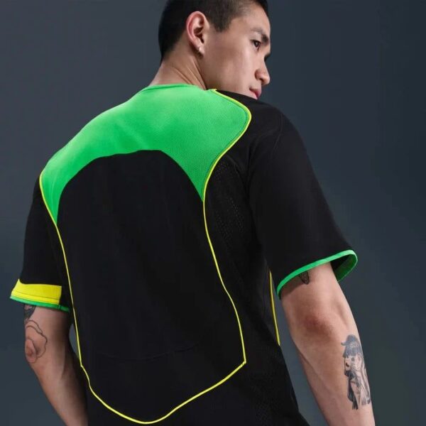 Back view of a man wearing a black shirt with a neon green back protector vest outlined in yellow.