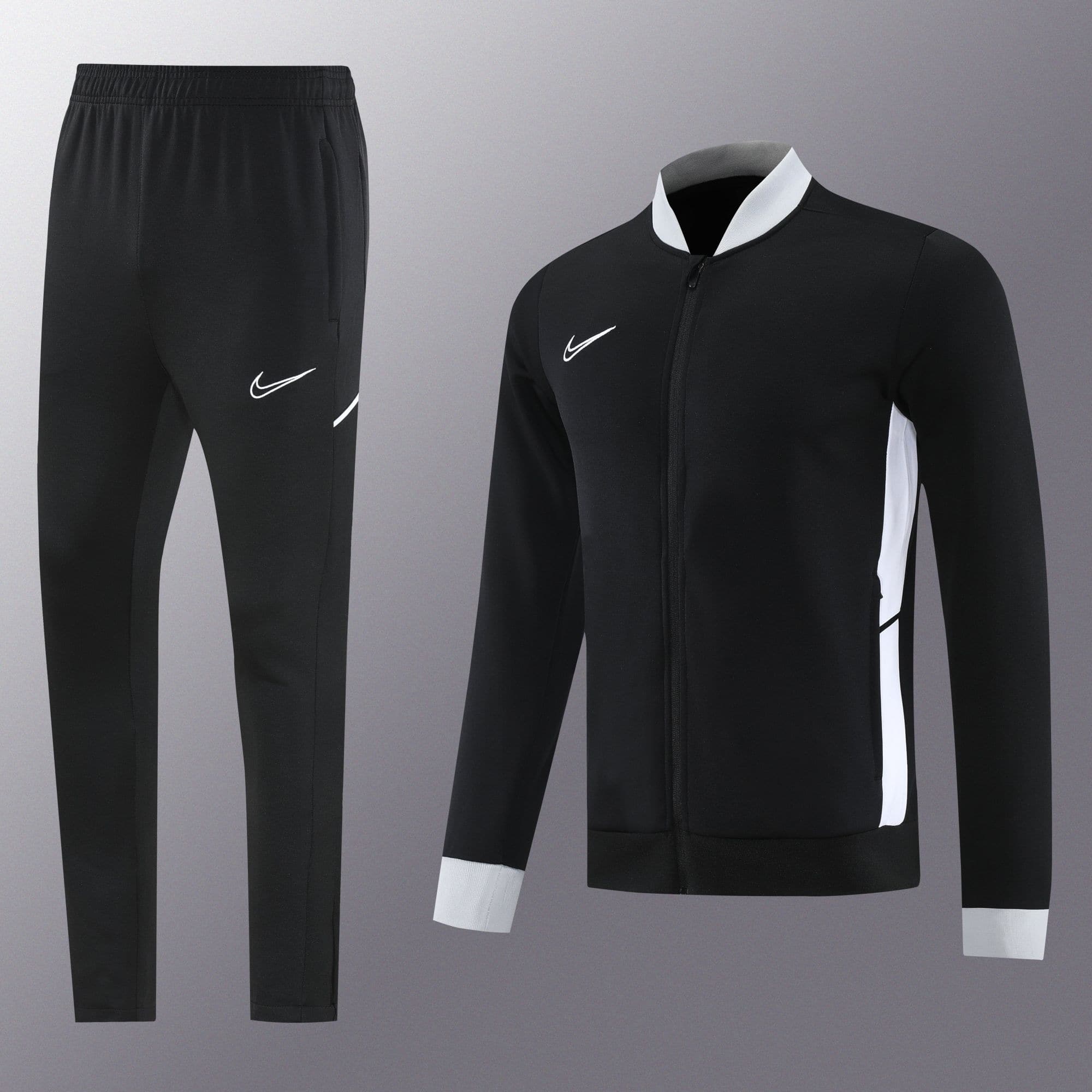 2fee83d1 | UAE SPORT STORE Black athletic tracksuit (pants and zip-up jacket) with white Nike swoosh logos and white side panels on the jacket.