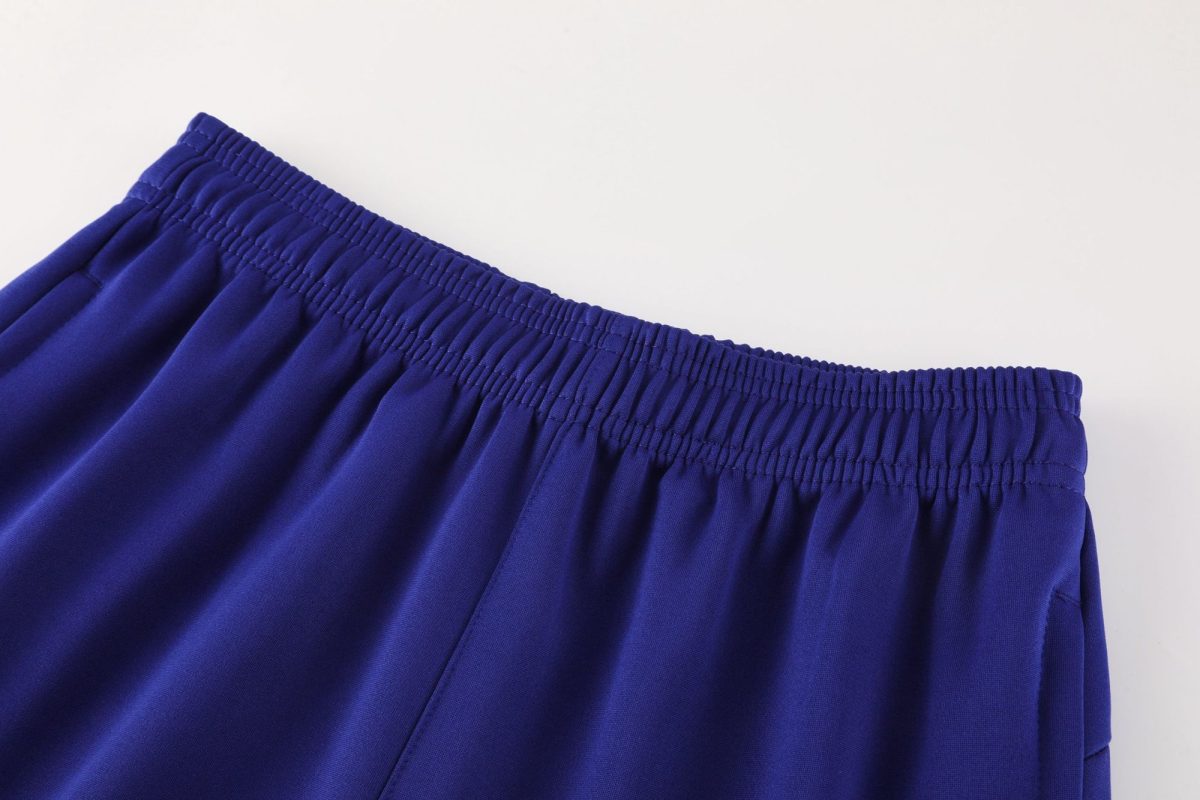 Close-up of a royal blue elastic waistband on fabric, showing gathered stitching and smooth material.