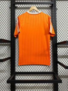 Bright orange striped sports jersey hanging on a wooden hanger against a black metal display rack in a store.