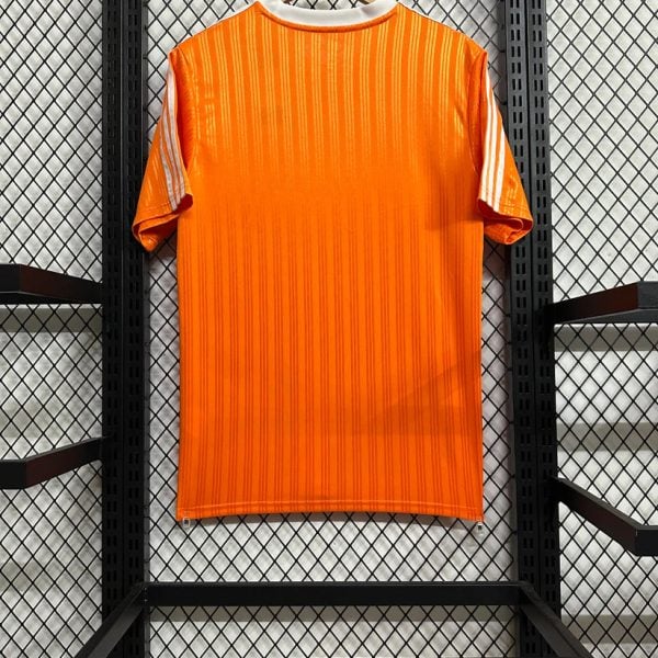 Bright orange striped sports jersey hanging on a wooden hanger against a black metal display rack in a store.