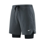 Gray Nike athletic shorts with an integrated black compression layer visible at the bottom, featuring a white swoosh logo on the leg.