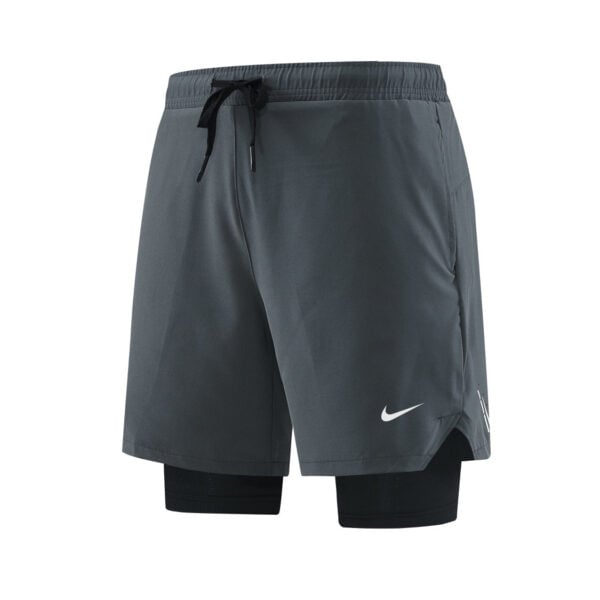 Gray Nike athletic shorts with an integrated black compression layer visible at the bottom, featuring a white swoosh logo on the leg.