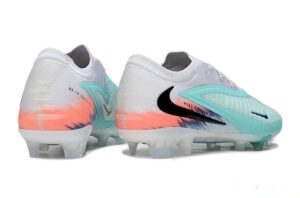 Pair of Nike soccer cleats, white with teal accents and a black swoosh, studded outsole on a white background.