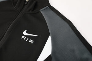 Close-up of a black Nike jacket showing the white swoosh and the word AIR, with a gray sleeve panel.