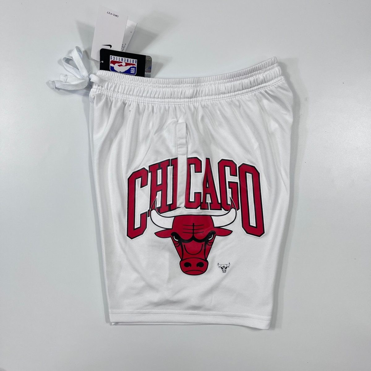 White Chicago Bulls basketball jersey featuring red and black 'CHICAGO' lettering and Bulls logo, with NBA tag visible.