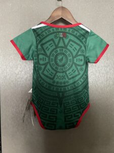 32224290 | UAE SPORT STORE Green t-shirt on hanger, red trim at neck and sleeves, showing an intricate geometric pattern on the back.