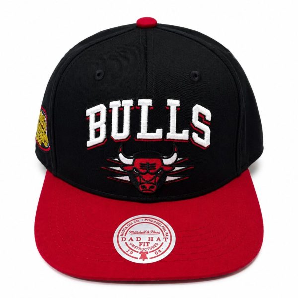 Black Chicago Bulls baseball cap with a red brim and bold white 'BULLS' embroidery on the front, featuring the team logo beneath.