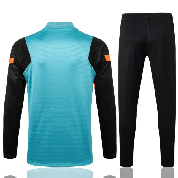 Turquoise goalkeeper jersey with black sleeves and orange armbands, paired with black athletic pants.