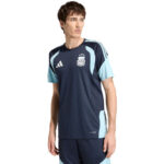 Male model wearing a dark navy Argentina training jersey with light blue panels on shoulders and sides, looking to the left.