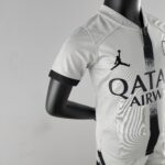 Close-up of a gray athletic shirt on a black mannequin, showing fabric texture and bold black graphic on the front near the chest area.