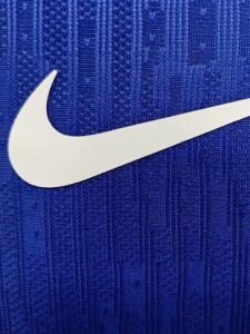 Close-up of a white Nike swoosh on blue fabric