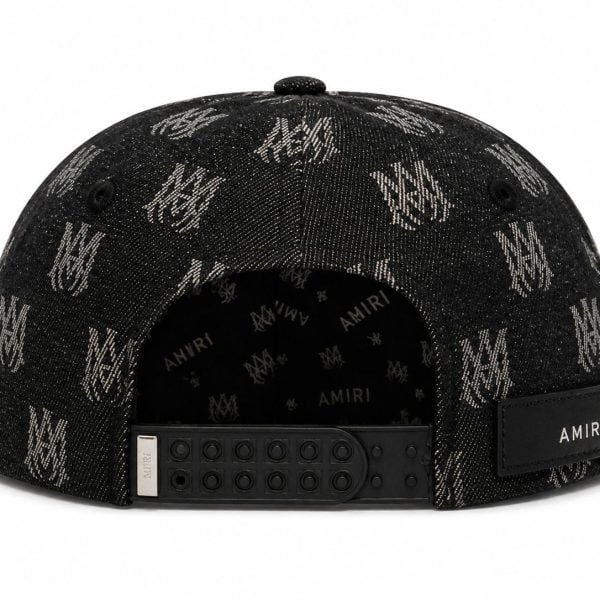 Back view of a black denim cap with an all-over AMIRI logo pattern, featuring an adjustable snap strap and a stitched AMIRI patch on the back.