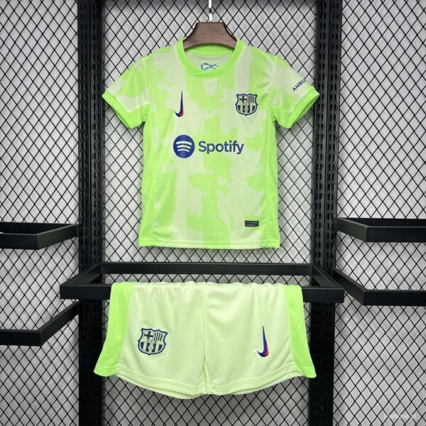 Bright neon lime Barcelona football kit on a hanger, with Barça crest, Nike swoosh and Spotify sponsor logo on the shirt; matching lime shorts with crest and swoosh beneath.