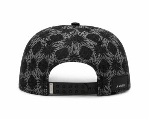 36c78eaa-5e35-4036-b49a-438526b3352f | UAE SPORT STORE Back view of a black and gray patterned snapback cap with an adjustable plastic strap and an AMIRI label on the back.