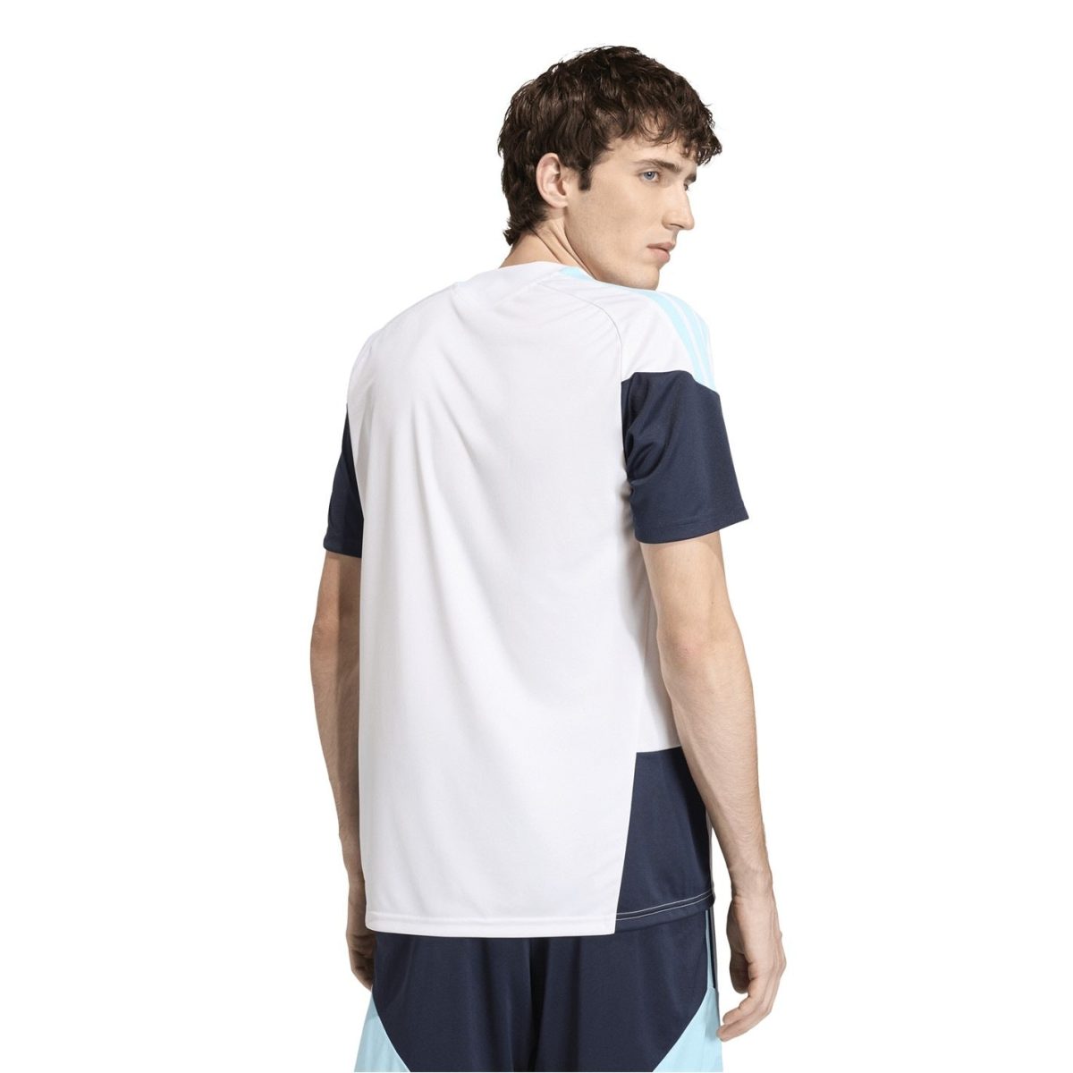 Back view of a young man wearing a white athletic T-shirt with navy sleeves and light blue panels, standing against a white background.