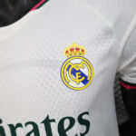 Close-up of Real Madrid club crest on a white jersey.