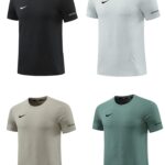 Set of Nike short-sleeve athletic tees in black, white, beige, and teal, each with the Nike swoosh and 'Just Do It' on the sleeve.