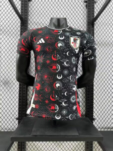 Mannequin wearing Japan national team jersey with black celestial print, containing red and white suns and moons, crest on chest, Adidas logo on the right.