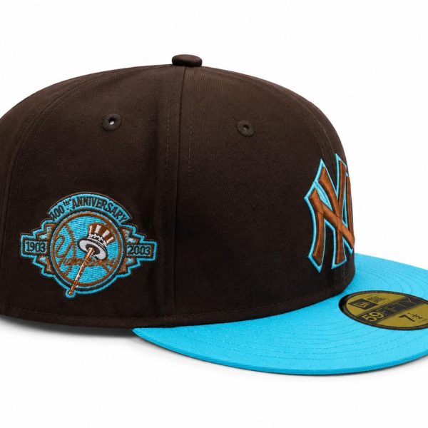 New York Yankees cap with a bright blue brim and brown crown, featuring teal embroidery and a commemorative anniversary patch on the side.
