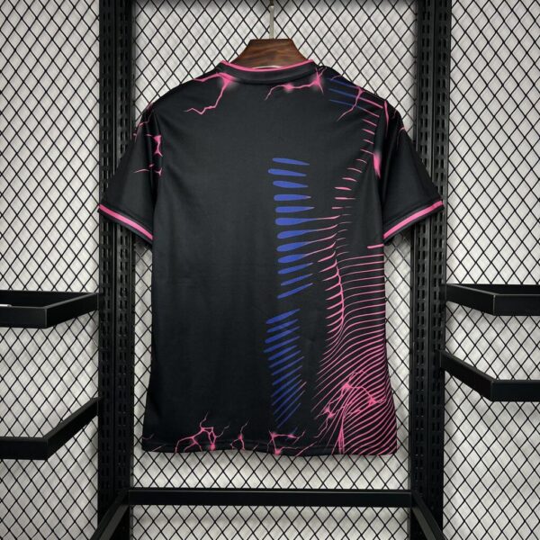Black T-shirt with pink neon cracks and blue curved lines, hanging on a hanger in a metal display rack.