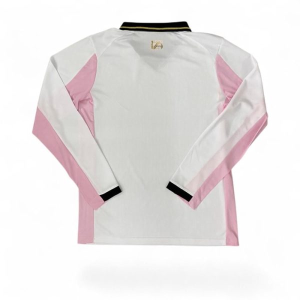 Back view of a white jacket with pink panels along the sleeves, black collar trim with gold stripe, and a small emblem on the upper back.