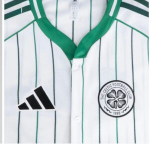 Close-up image of a white striped Celtic football jersey with green accents, showing the Adidas logo and Celtic FC crest on the chest area.
