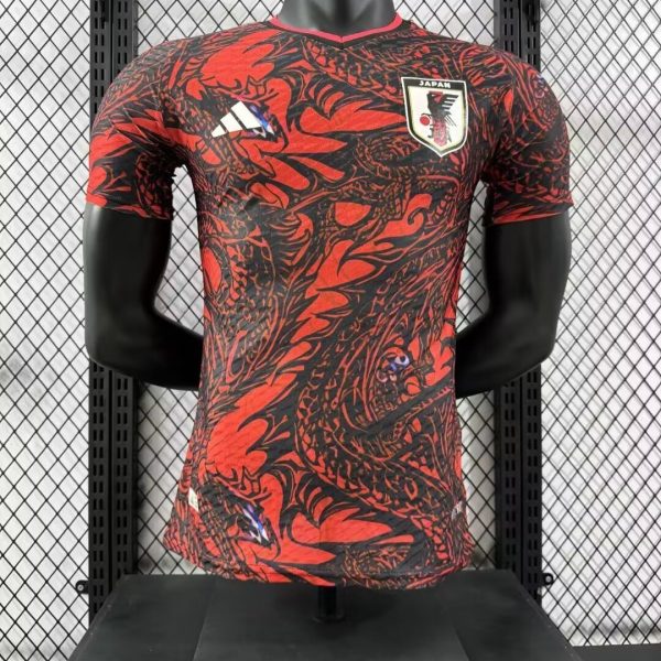 Japan national team football jersey with a red and black abstract pattern on a display mannequin, featuring the crest and Adidas logo.