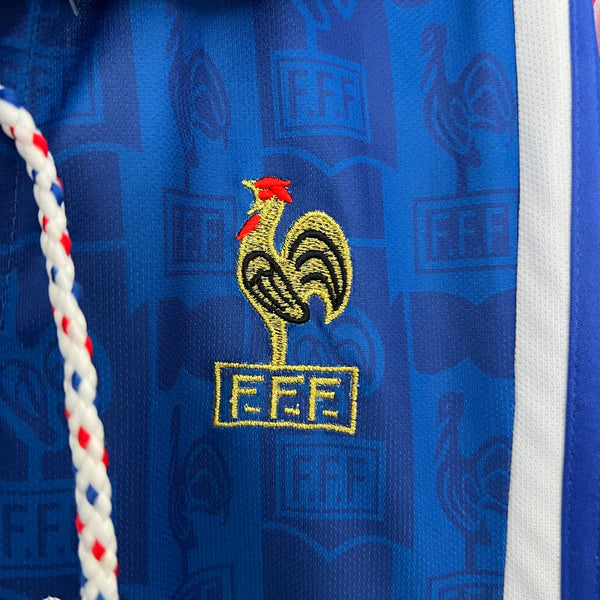 3a8f6ba7 | UAE SPORT STORE Close-up of blue fabric with gold embroidery of a rooster and the FFF crest, beside a white-and-red rope.