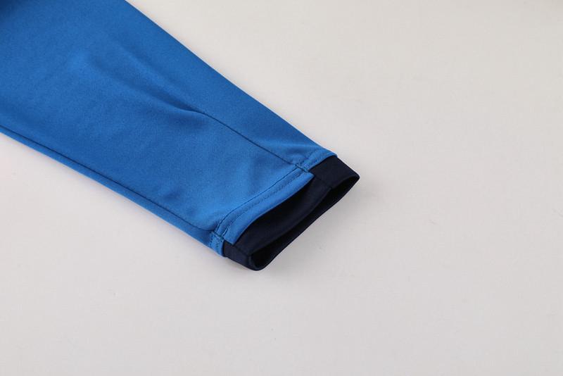3b2aedb6-34c8-4d07-8f0d-62cc43f15b5c | UAE SPORT STORE Blue jacket sleeve with a dark navy cuff laid on a light surface.