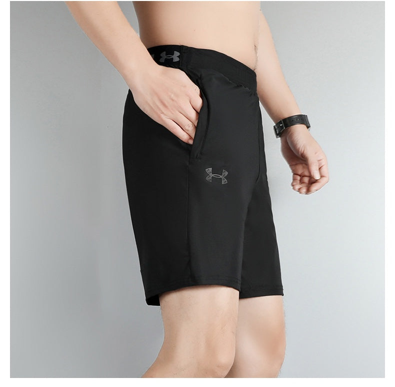 3be45aec | UAE SPORT STORE Side view of a man wearing black athletic shorts with a side pocket and Under Armour logo visible on the leg.