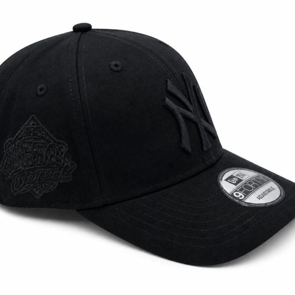 Black baseball cap with a curved brim, featuring an embroidered crest on the side and a subtle front emblem; adjustable strap at the back.