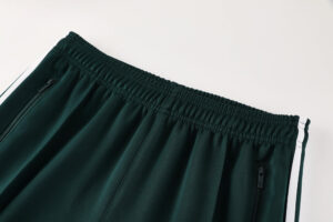 Dark green athletic pants with an elastic waistband and zippered side pockets shown from the back/side view.