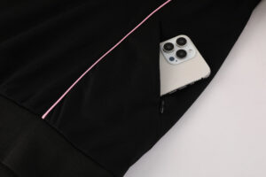 3c6f52fc | UAE SPORT STORE Black hoodie with a pink drawstring; a smartphone peeks out from the pocket edge.