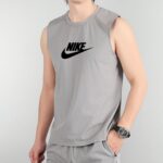Person wearing a gray sleeveless Nike tank top with a black Nike swoosh logo on the chest.