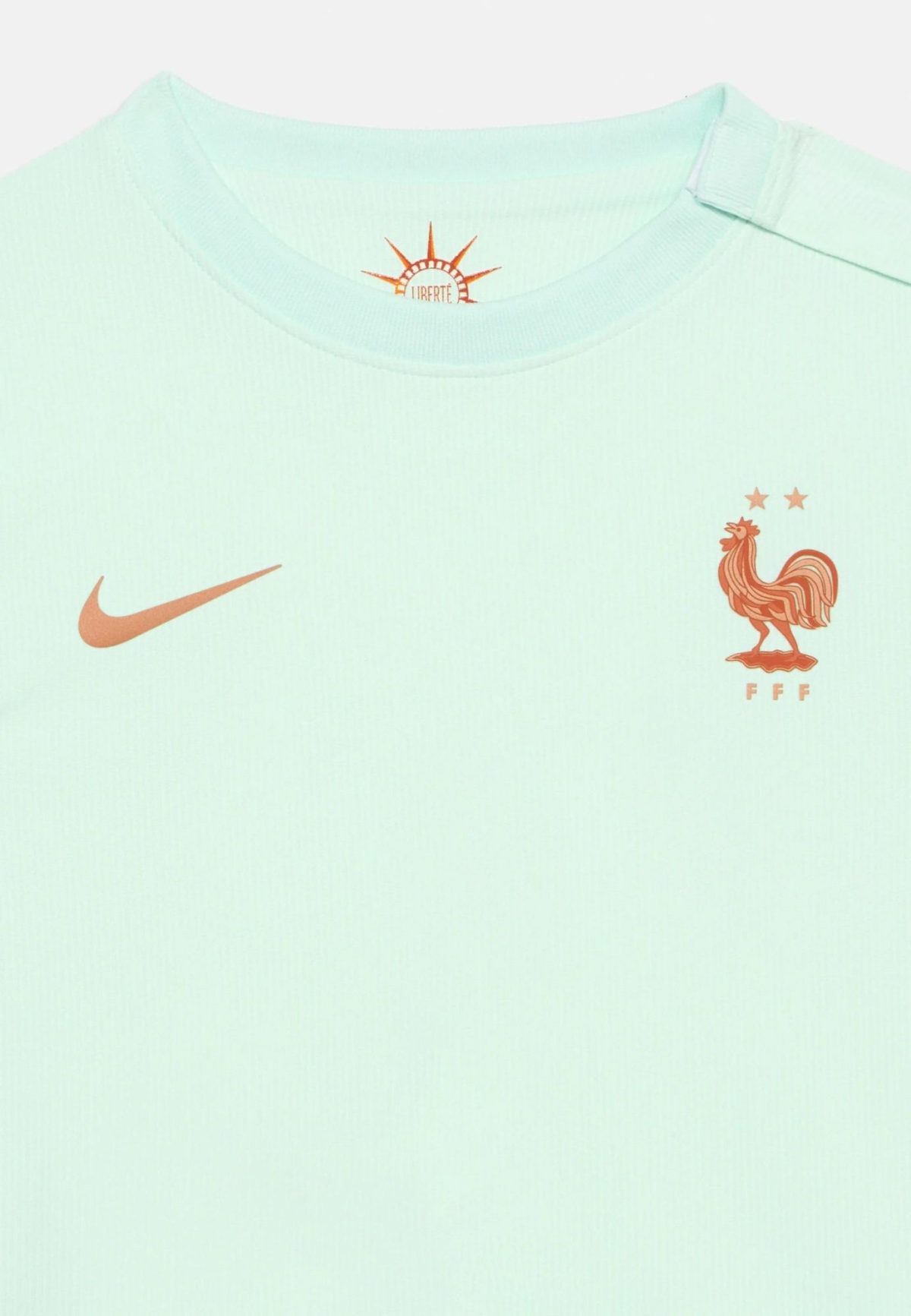 Mint-green Nike T-shirt featuring the French Football Federation crest (rooster) on the chest, with a Nike swoosh nearby.