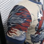 Close-up of blue, red, and beige wavy patterned fabric upholstery on a seat.