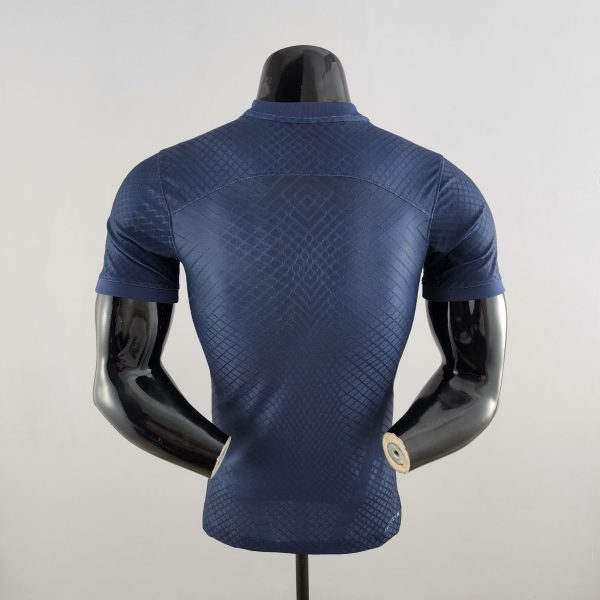 Back view of a navy blue, quilted short-sleeve shirt on a mannequin.
