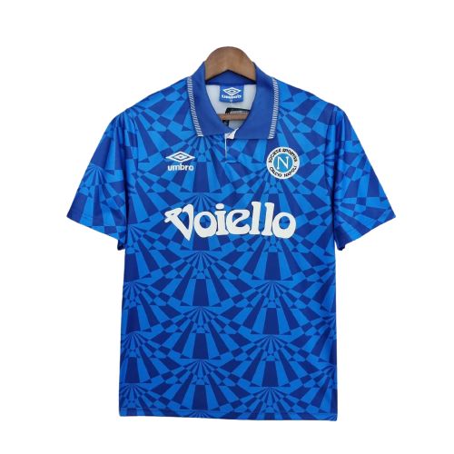 Blue Napoli soccer jersey on a hanger with a geometric pattern, featuring the Umbro logo, Napoli crest, and 'Voilello' sponsor across the chest.
