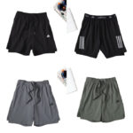 Four Adidas athletic shorts (black, black with side stripes, gray, and olive green) laid out with drawstrings and small logo visible on each pair.