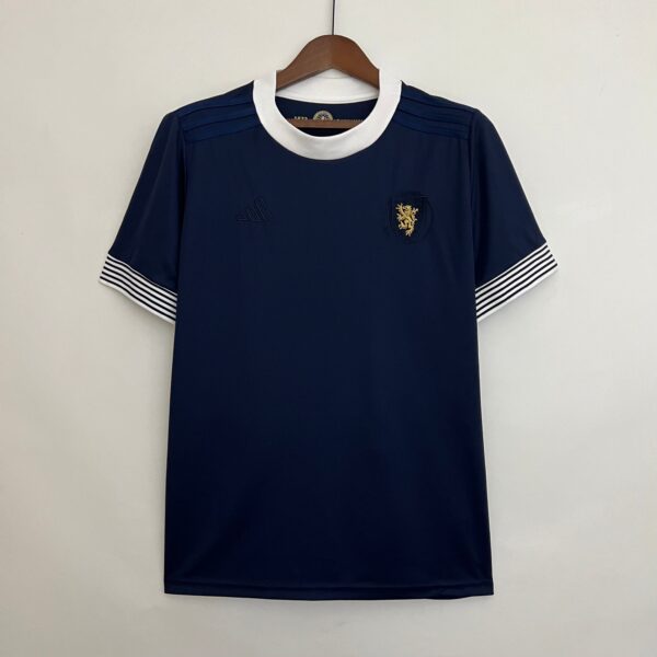 Navy blue polo shirt on a wooden hanger, with a white rounded collar and striped white-and-navy cuffs, crest emblem on the left chest.