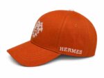 Heritage Crest luxury cap with Hermes branding, orange color, stylish and high-quality design.