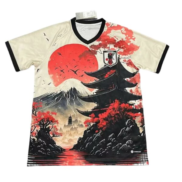 Japan-themed athletic jersey with cream base, black trim, and a bold print of a pagoda, red sun, cherry blossoms, and a coastline with Mt. Fuji; JFA crest on the chest area.